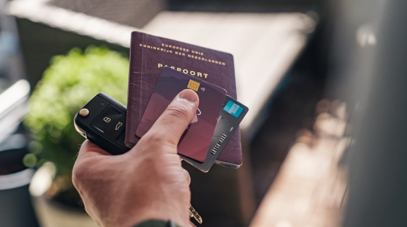 Mão segurando passaporte e cartão