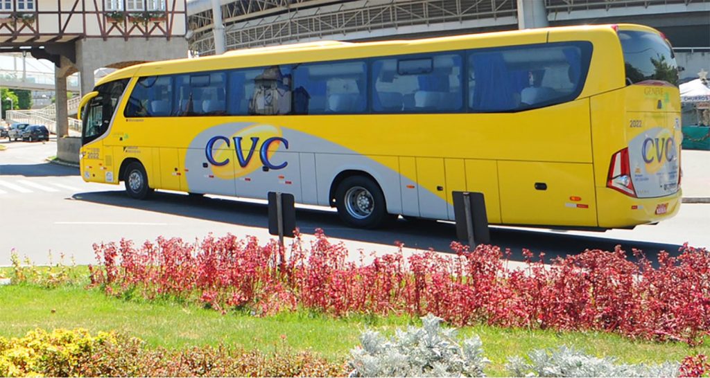 Onibus amarelo com logo da CVC estacionado