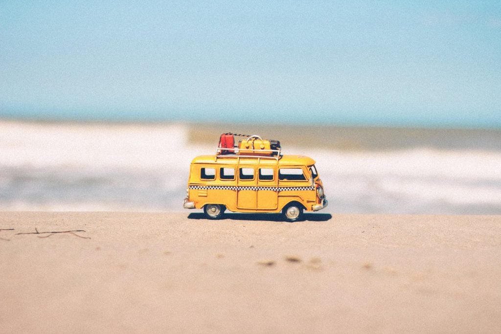 Mini combi amarela na areia da praia