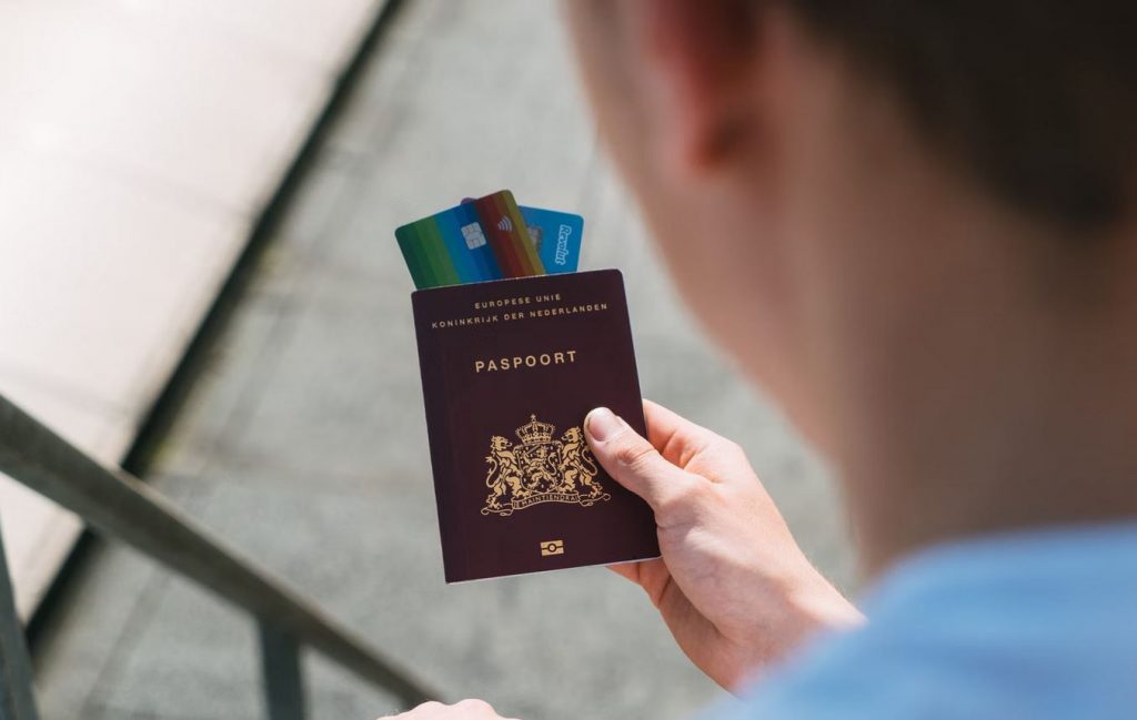 Pessoa segurando passaporte com cartões