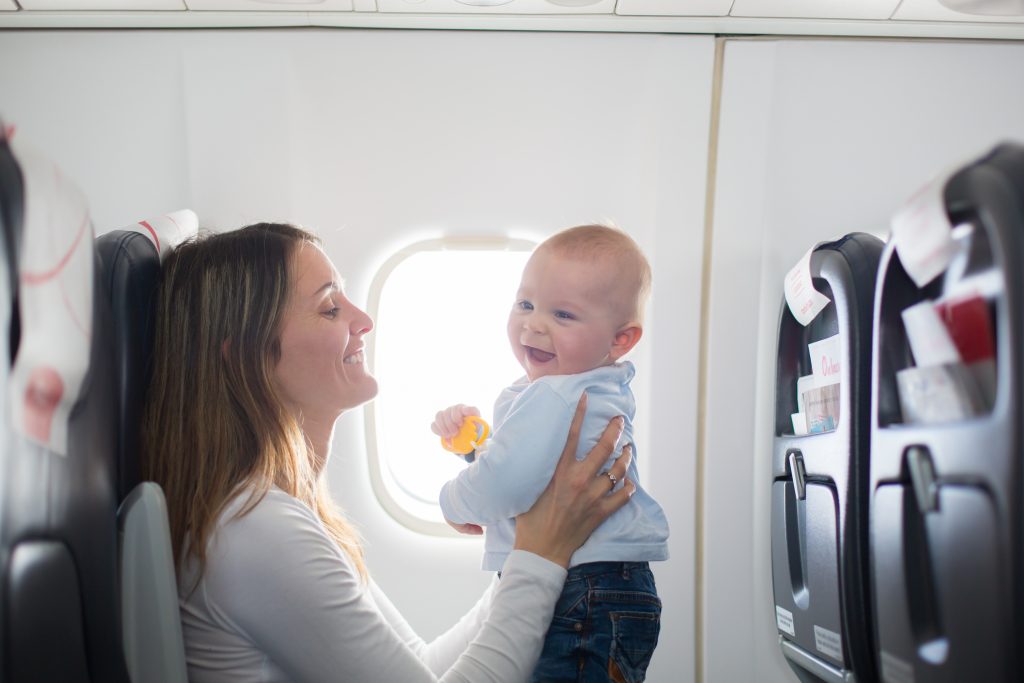 Mãe brincando com bebê no avião