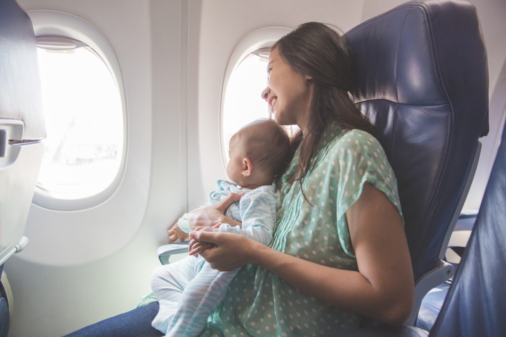 Mãe com criança no colo em avião
