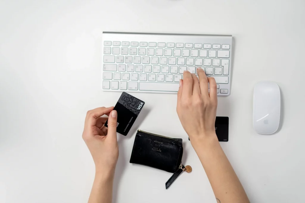 Mão segurando cartão black e usando teclado
