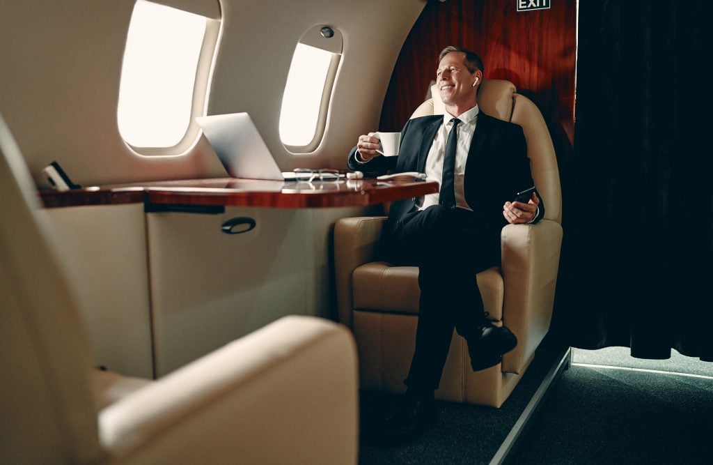 Homem de negócios sentado em classe Executiva de avião