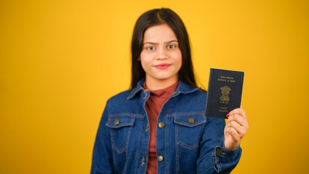 Menina segurando passaporte da Índia
