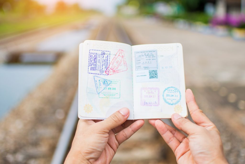 Mão segurando passaporte carimbado