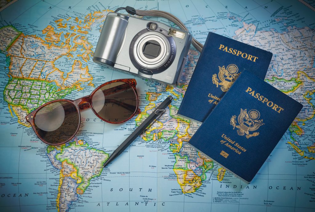 Mapa com câmera, óculos e passaporte em cima