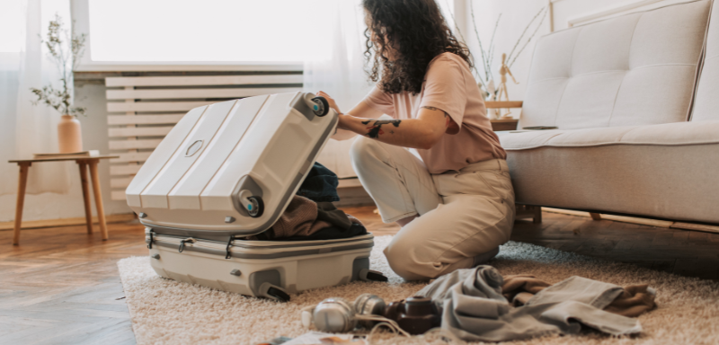 Woman packing travel items.